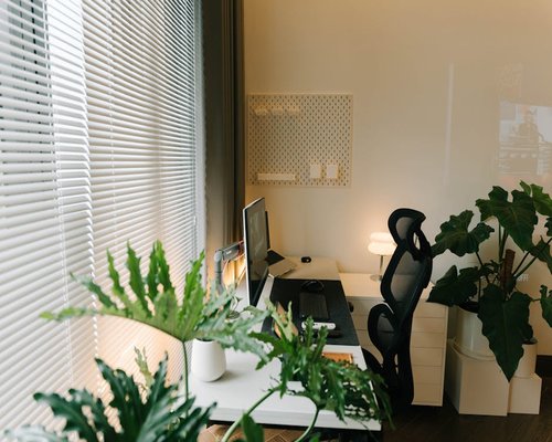 A bright home office setup in Medellin with an ergonomic chair near a window with natural light