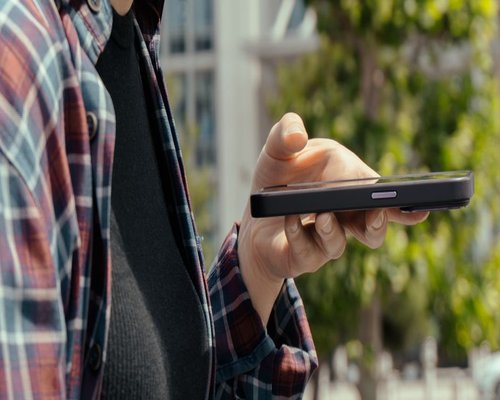 Close-up view of hands holding a smartphone at an eye-level angle, promoting correct alignment during day breaks